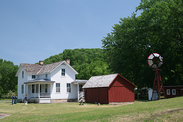 White house next to red barn in a field