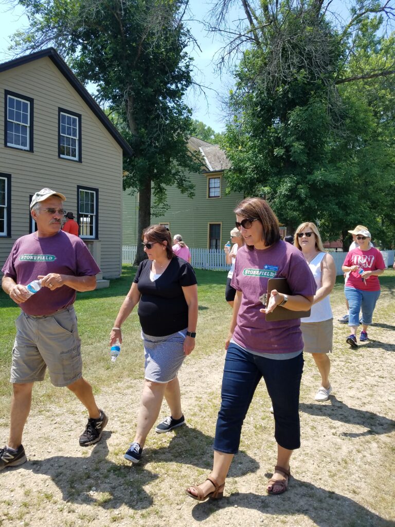 A large group of staff and guests walk through Stonefield.
