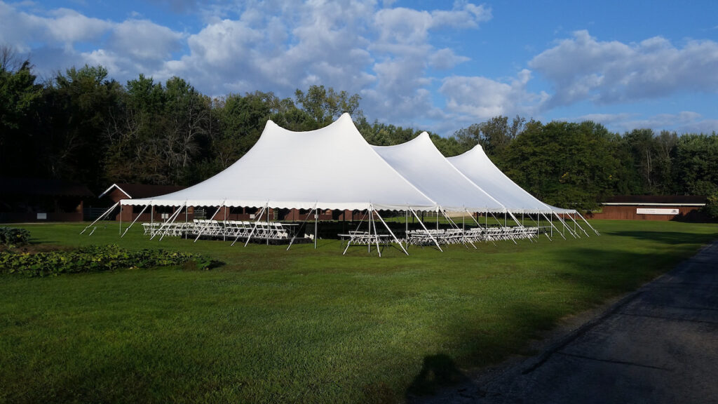 A green grassy area with white tents for a wedding event