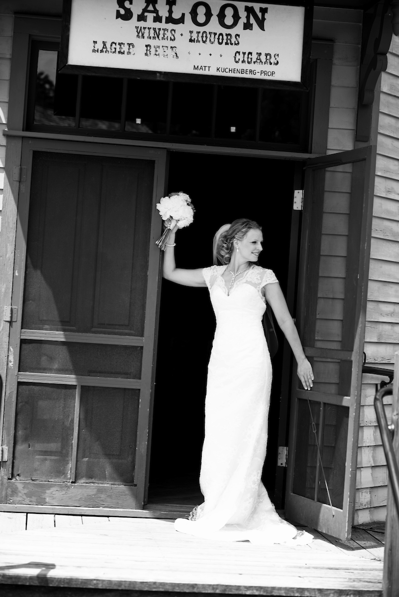 A black and white photo of a bride throwing her flower bouquet