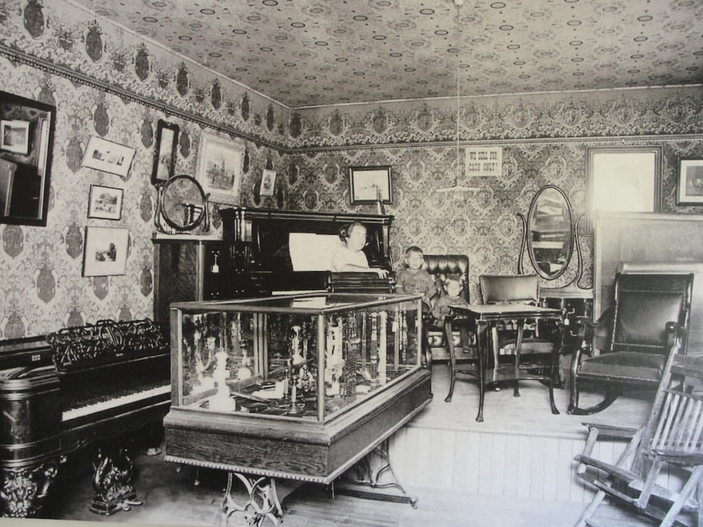 Catherine Dunn Dewey standing with her left forearm on a bedframe